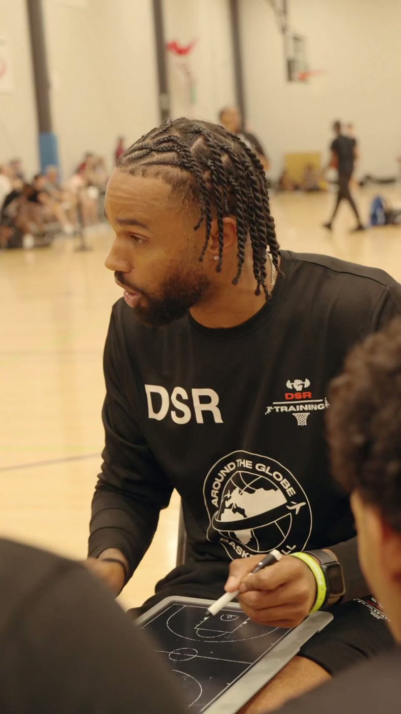 Dom drawing up a play on a clipboard